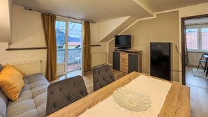 A modern living room with a dining table, sofa, and TV. - Apartment Frank by Interhome (Feldkirchen in Kärnten)