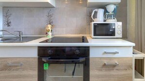 Een moderne keuken met een ingebouwde oven, magnetron en koffiezetapparaat.