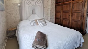 A bedroom with a large bed, a wooden wardrobe, and a unique ceiling design. - La Congrière by Interhome (Cancale)