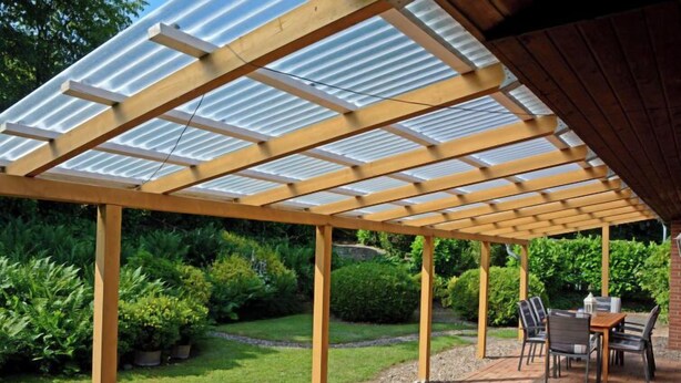Un patio abrité, doté d’une pergola en bois et d’un sol en briques, entouré de verdure.
