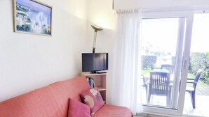 A living room with a sofa, a television, and a view of the outdoors. - Zirlinga by Interhome (Bidart)