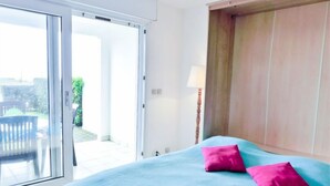 A bedroom with a bed, two pillows, a sliding glass door, and a lamp. - Zirlinga by Interhome (Bidart)