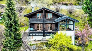 Eine Blockhütte mit Balkon und einer Treppe, die zum Eingang führt.