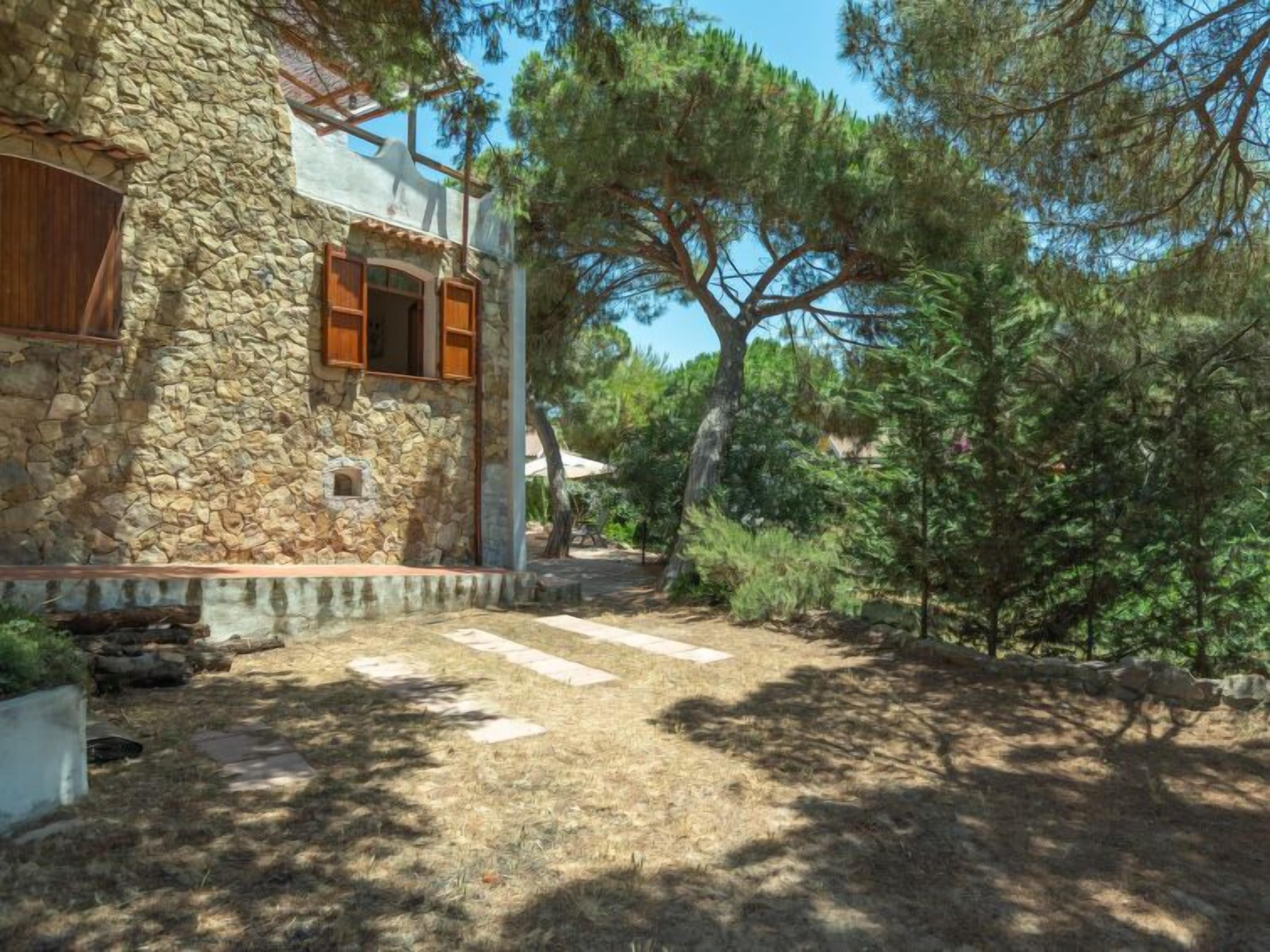 A stone building with a stone pathway leading to a wooden door.