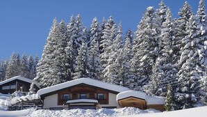 A wooden lodge surrounded by snow-covered trees.