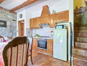 A kitchen with wooden cabinets, a stove, oven, and a refrigerator.