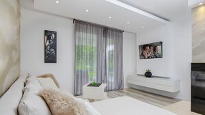 Ein modernes Wohnzimmer mit einem weißen Sofa, einem kleinen Beistelltisch und einer weißen Ablage.