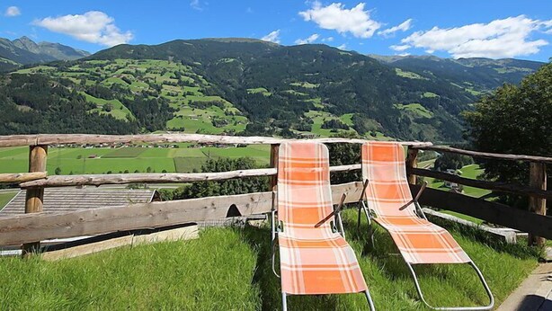 A wooden fence with two plaid chairs facing a mountainous landscape. - Apartment Hanna by Interhome (Kaltenbach)