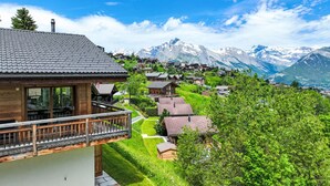 A mountain village with traditional wooden houses, a clear sky, and snow-capped mountains in the background. - Vacation home D'Arby by Interhome (Nendaz)