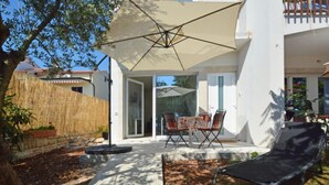 An outdoor patio area with a covered seating area, a stone pathway, and a lounge chair. - Apartment Mira by Interhome (Umag)