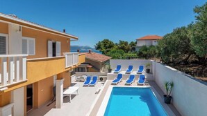 Un espace piscine avec des chaises longues et vue sur la mer.