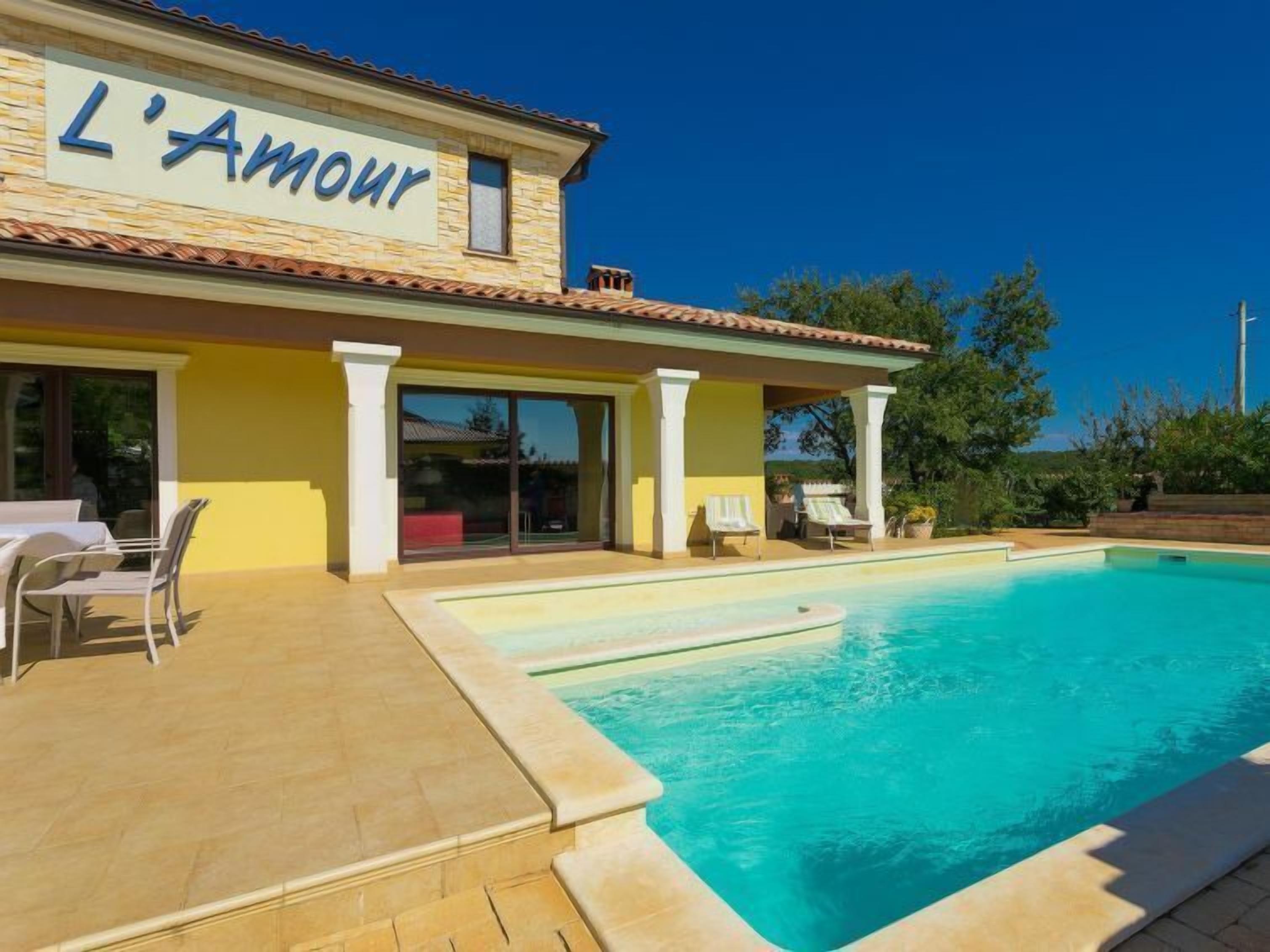 A hotel named 'L'Amour' with a swimming pool and outdoor seating area.
