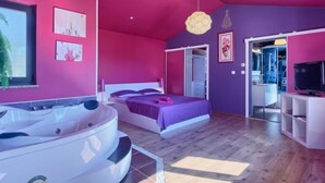 Une chambre moderne avec un grand lit, un jacuzzi et une télévision.