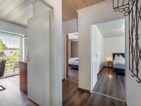 Ein modernes Schlafzimmer mit Bett, Nachttisch und Blick ins Freie.