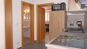A modern kitchen with a built-in microwave, a sink, and a countertop with a glass surface. - Apartment Susi by Interhome (Flirsch)