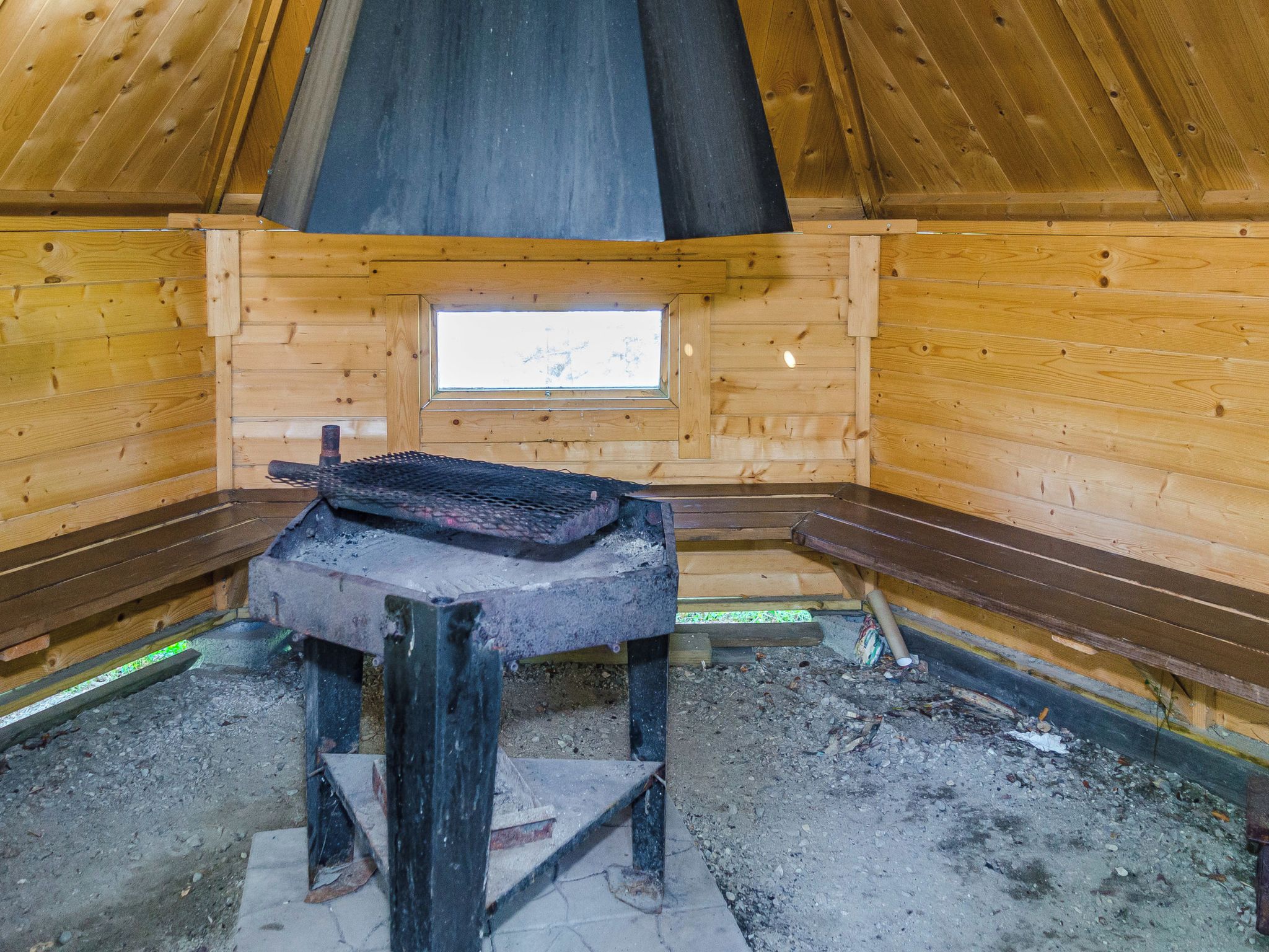 Un sauna équipé de bancs, d’un système de chauffage intégré aux bancs et d’une fenêtre.