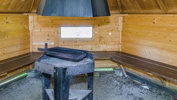 Un sauna équipé de bancs, d’un système de chauffage intégré aux bancs et d’une fenêtre.