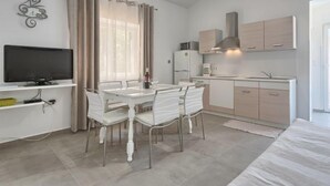 Een moderne keuken met witte kastjes, een inbouwoven en een magnetron.