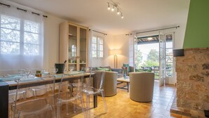 A dining area with a wooden table, clear chairs, and a glass cabinet.