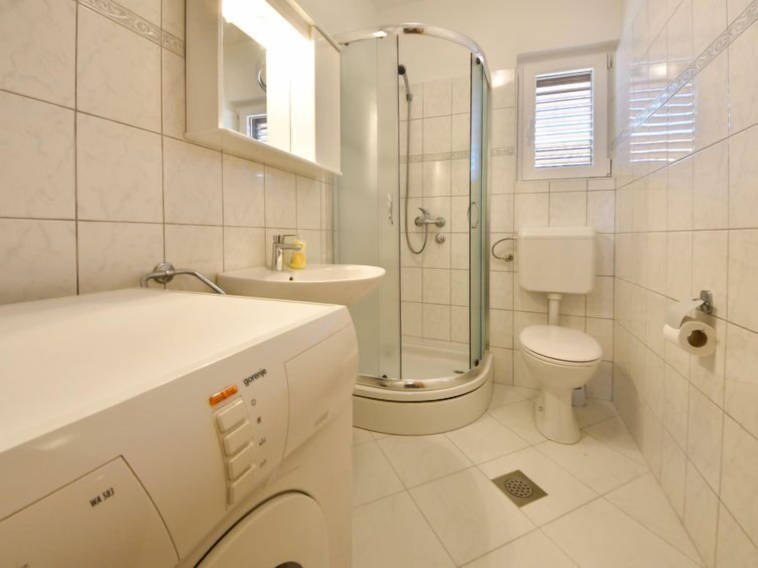 Un bagno moderno con doccia vetro, toilette e lavandino.