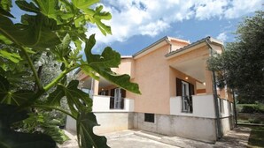 Une maison moderne à deux étages, dotée d’un balcon, d’un chemin en pierre et d’un jardin.