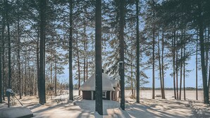 A cabin surrounded by tall pine trees in a snowy landscape. - Vacation home Ojala by Interhome (Kuusamo)