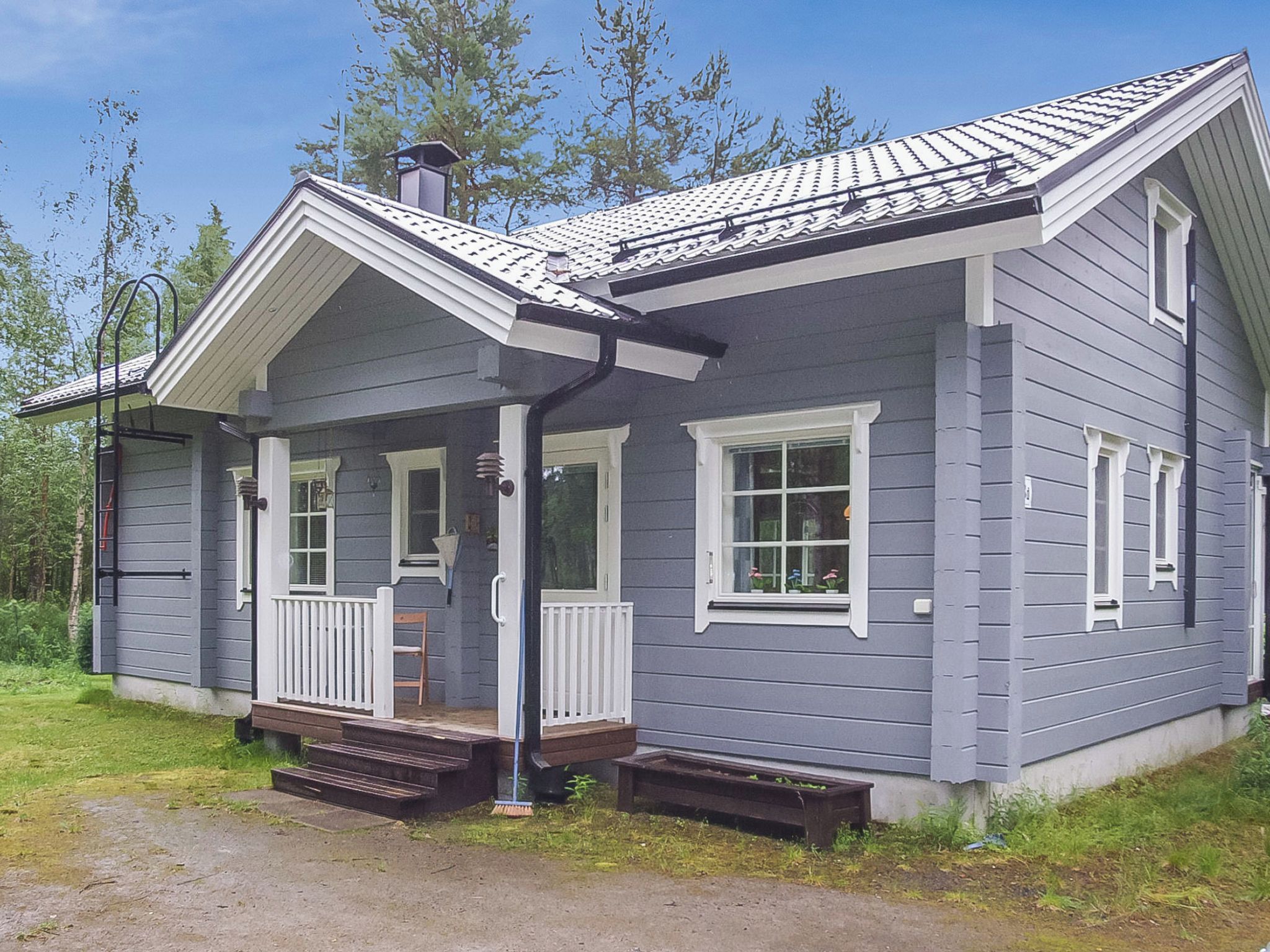 A single-story house with a porch, a chimney, and a small front yard.