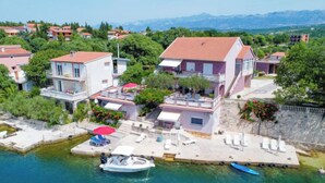 Un quartier résidentiel situé sur la côte, avec des maisons, un quai et un bateau.