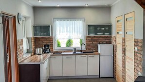 Una cocina compacta con ventana, estufa integrada y un lavamanos.