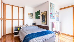 A bedroom with a large bed, wooden wardrobe, bookshelves, and artwork on the walls. - On the terraces of Rosa you are constantly forced to look at the sky and Rome (Roma)