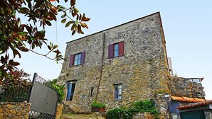 Edifici de pedra amb dues finestres i un petit portal.