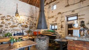 Eine rustikale Küche mit Steinwänden, Holzmöbeln und einem Steinofen.