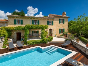 A villa with a swimming pool, outdoor seating, and a garden. - Vacation home Gelci by Interhome (Trget)