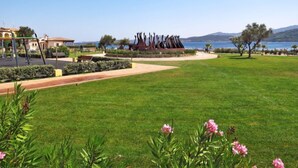 A park with a sculpture, a playground, and a view of the sea. - Apartment Paola by Interhome (Cannigione)