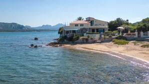 A coastal property with a large house, a beach, and a view of the sea and mountains. - Apartment Paola by Interhome (Cannigione)