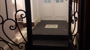 Una puerta que da a un cuarto con una puerta blanca y un felpudo negro en la entrada.