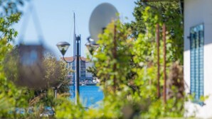 Une vue d’une zone riveraine avec des bâtiments, un lampadaire et de la végétation.