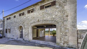 Un edificio de piedra con entrada cubierta y vistas del paisaje circundante.