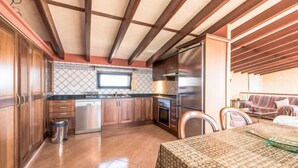 Una cocina moderna con armarios de madera, electrodomésticos de acero inoxidable y salpicadero azulejado.