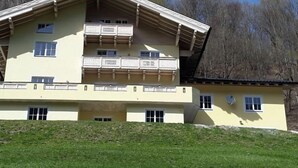 Un immeuble à plusieurs étages doté de balcons, d’un toit en pente et d’un parterre gazonné.