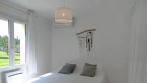 A bedroom with a bed, a hanging dreamcatcher, and a window with curtains. - Siflora by Interhome (Saint-Rémy-de-Provence)