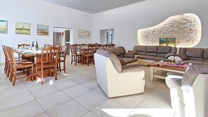 A spacious living area with a dining table, sofas, and a stone accent wall.
