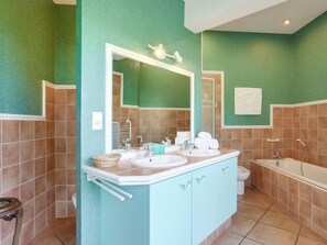 A bathroom with two sinks, a mirror, a bathtub, and a toilet. - Les Pinasses by Interhome (Mimizan)