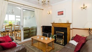 Una sala de estar con chimenea, un sofá, una mesa de centro y una televisión.