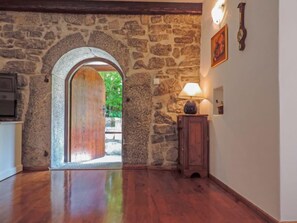 Experience the rustic charm of this cozy retreat, featuring a stone archway leading to an outdoor space and a simple, clean design.