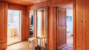 Un intérieur en bois comprenant une salle de bain, un miroir et une porte donnant sur une autre pièce.