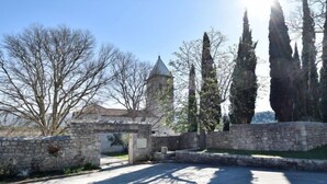 A stone archway leading to a building with a tower, surrounded by trees and a clear sky. - Apartment Karla by Interhome (Novigrad (Zadar))