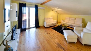 A spacious living room with a wooden floor, white sofas, a glass coffee table, and a ceiling fan. - Apartment Karla by Interhome (Novigrad (Zadar))