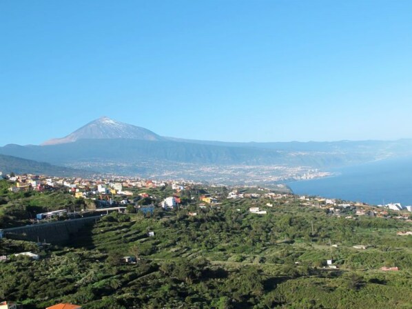 A coastal town with a prominent mountain in the background, terraced fields in the foreground, and a clear view of the sea. - Vacation home Pepa by Interhome (Granadilla)