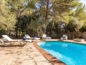 A swimming pool with lounge chairs and a stone patio. - Villa Pinos by Interhome (L'Ametlla de Mar)